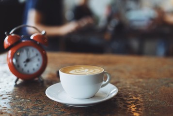A cup of coffee on rustic background with beautiful latte art in the coffee shop