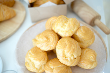 croissants and Choux Cream and Eclair on brown white table.