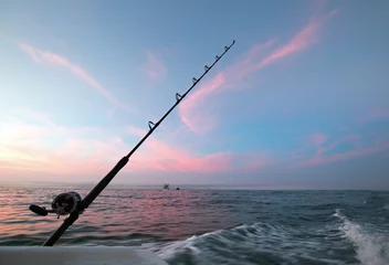 Photo sur Plexiglas Pêcher Fishing rod on charter fishing boat against pink sunrise sky on the Sea of Cortes in Baja Mexico BCS