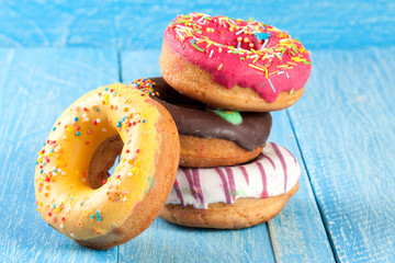 pile of glazed donuts on a blue wooden background
