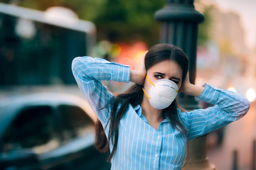 Girl With Mask Covering her Ears Because of Noise Pollution