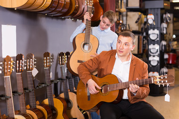 Father helps his son to choose a guitar