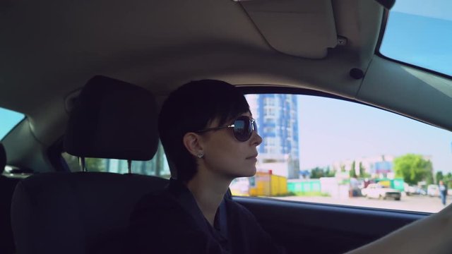 Portrait woman with short black hair drive car. Female drive on the road in urban city.