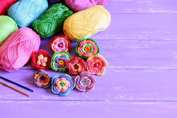 Bright crochet flowers set. Homemade crochet flowers, varicolored cotton yarn, crochet hooks on...