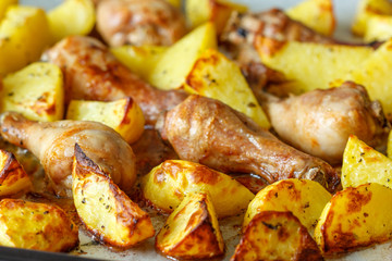 Baked potatoes with chicken on a baking sheet.