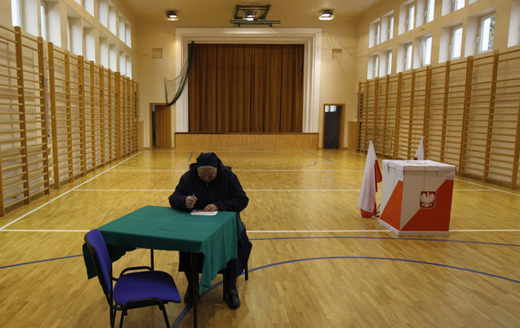 A Catholic nun fills out her ballot paper before casting her vote at a polling station in Warsaw