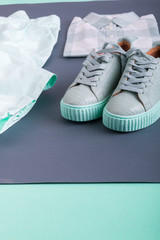 Fototapeta na wymiar Summer or spring female mint color outfit. Shirt, pants, sneakers on grey background. Close up