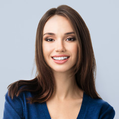 young smiling woman in blue clothing, over grey