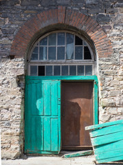 Fototapeta na wymiar Double green wooden door with broken leaf