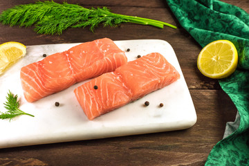 Two slices of salmon on dark background with copyspace