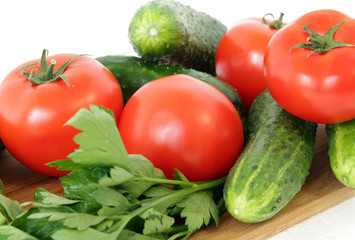 tomatoes, peppers ,cucumbers and parsley on a cutting Board