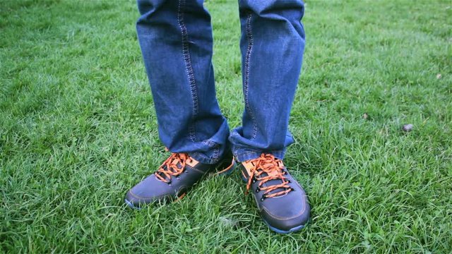 man in sneakers on the grass/man feet in sneakers on the grass