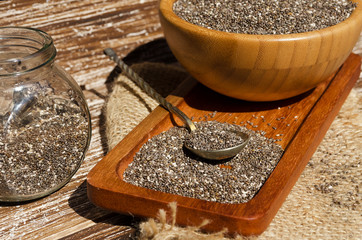 Close up of spoon with chia seeds (Salvia hispanica) on wooden plate. This superfood is a rich in omega-3 fatty acids, essential for good health. Healthy eating , vegan diet concept.