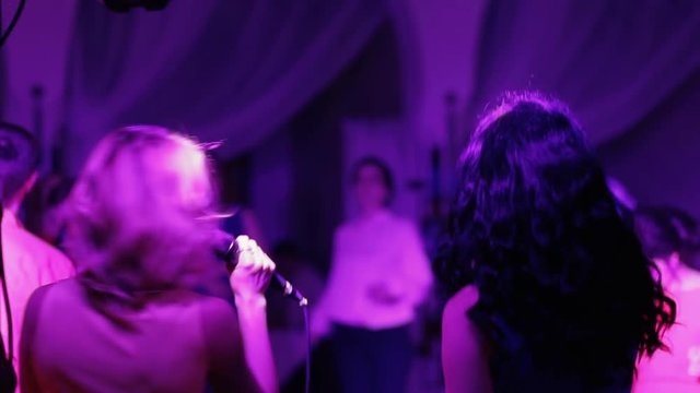 Beautiful charismatic two women singer performing at music event