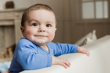 Fototapeta premium Portrait of funny baby boy looking at camera with smile