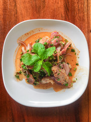 Sliced grilled pork salad Thai food on wood background