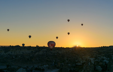 Hot air balloons flying over valley at sunrise. Cappadocia. Turkey