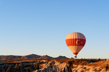 Naklejka premium Hot air balloon flying over valley at sunrise. Cappadocia. Turkey