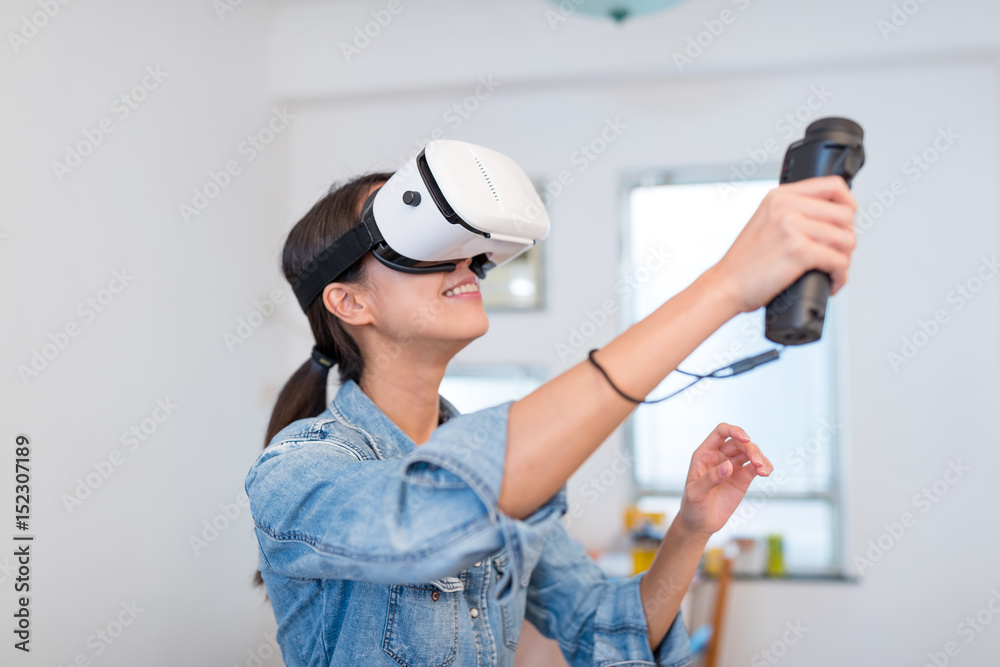 Wall mural woman playing game with virtual reality