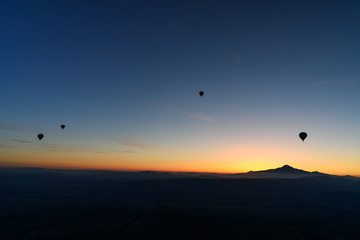 Hot air balloons flying over valley at sunrise. Cappadocia. Turkey