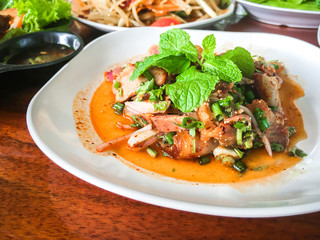 Sliced grilled pork salad Thai food on wood background