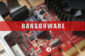 Blurred of a circuit board with big microchip . Cyber security concept with ransonware text