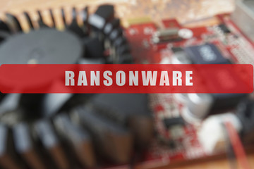 Blurred of a circuit board with big microchip . Cyber security concept with ransonware text