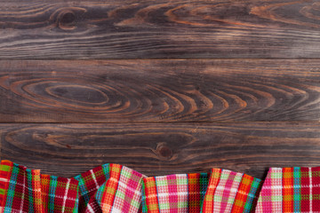 Red checkered tablecloth on a dark wooden table with copy space for your text. Top view