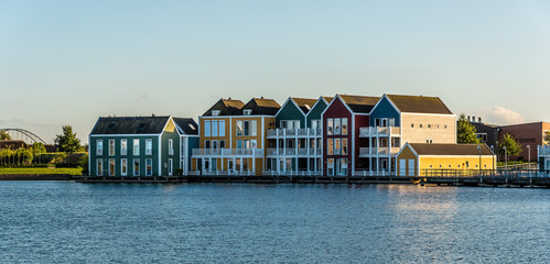 Colorful row houses in Houten, Netherlands, at dusk and reflections on water