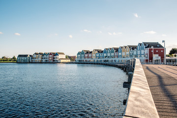 Fototapeta premium Colorful row houses in Houten, Netherlands, at dusk and reflections on water