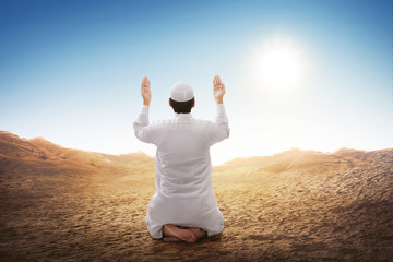 Rear view of asian muslim man sitting and praying
