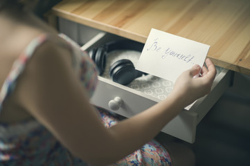 The girl with headphones and  message be yourself. 
