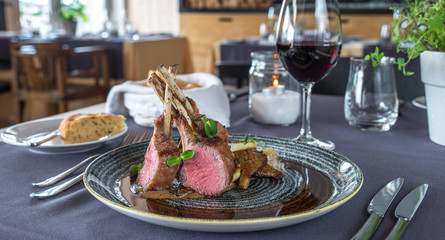 Roasted lamb chops with chanterelles and vegetables on decorated table