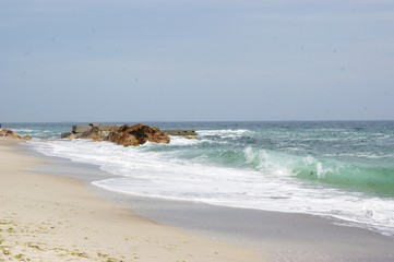 The sea, the blue aod, the waves are rooted about the stones. Summer, beach