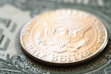 One dollar bill and half dollar coin close up