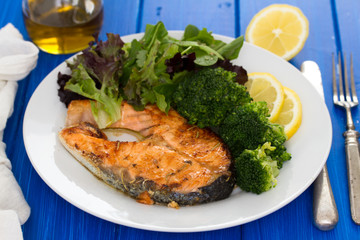 fried salmon on dish on wooden background