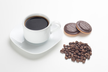 White cup, black coffee, beans and cakes