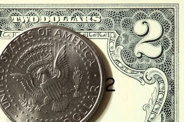 Two dollar bill and half dollar coin close up