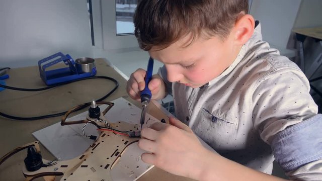 Steadicam of the boy soldering copter, drone. 4K.