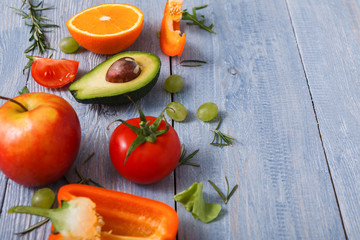 Border of fresh vegetables on blue wood background with copy space