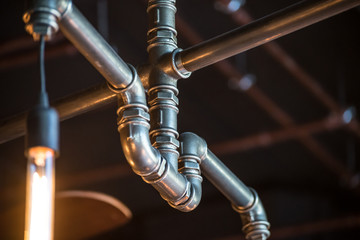 Pipes, fittings and lamp on dark background