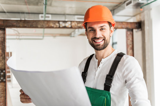 Hilarious smiling builder keeping document