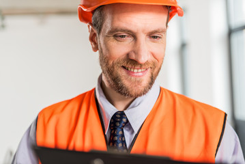 Jolly smiling constructor wearing hardhat
