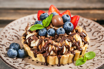 Banoffee chocolate pie decorated with chocolate, fresh blueberry and strawberry