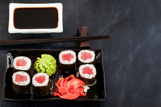 Fresh delicious tuna maki sushi rolls on dark background