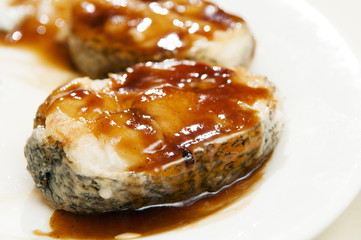 Closeup of Cod fish with honey sauce on white plate
