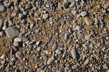 Background of sea pebbles on a sandy beach