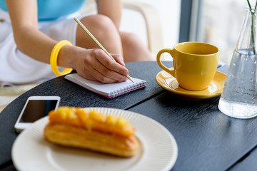 Elegant lady sitting at table and writing down her thoughts