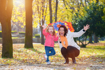 Naklejka na ściany i meble Mother and daughter have a fun in autumn park.Lens flare
