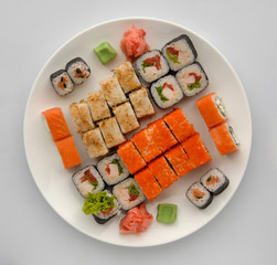 sushi on a round plate on a white background. sushi roll close-up, top view